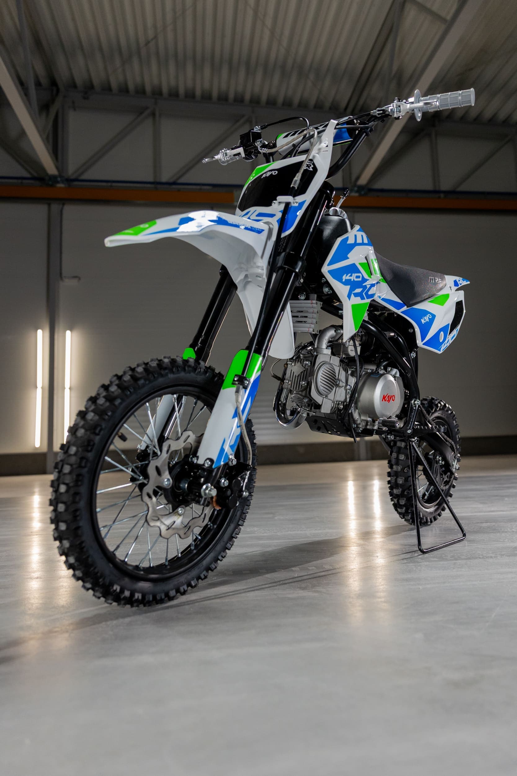 Rider on dirt bike performing maintenance